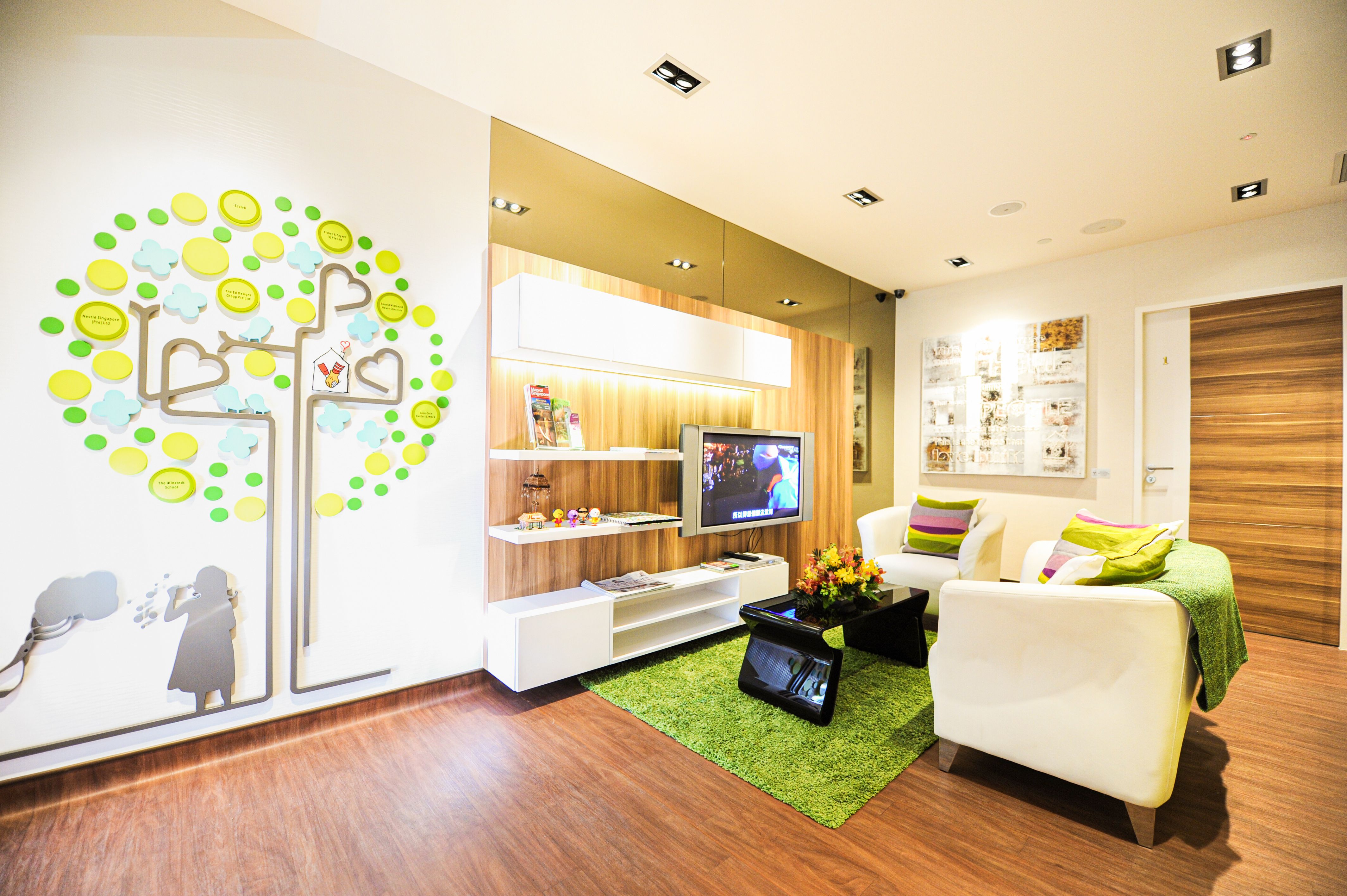 A bedroom in the Ronald McDonald House with two single beds, a desk and a bedside lamp.